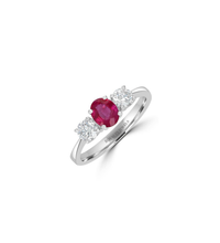 Three-stone 14K white gold ring featuring an oval ruby flanked by two round diamonds on each side.