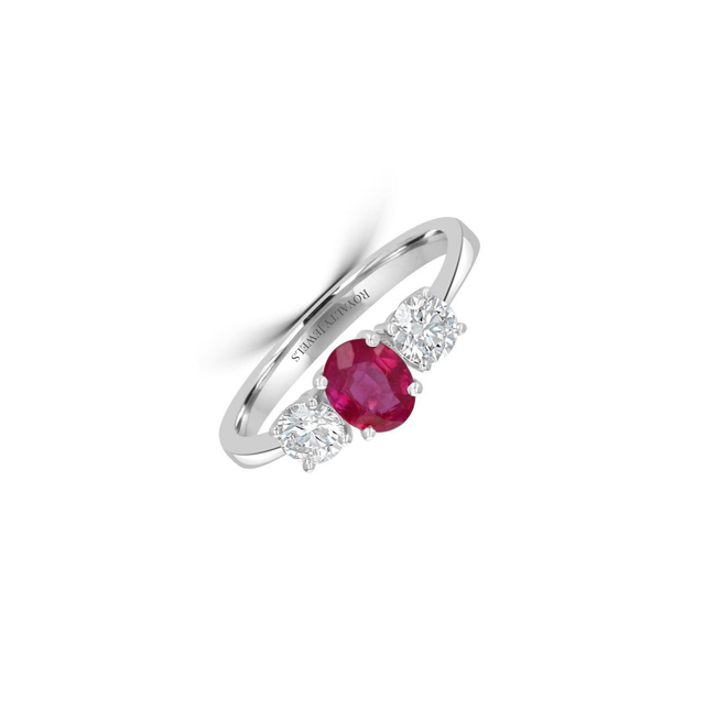 Three-stone 14K white gold ring featuring an oval ruby flanked by two round diamonds on each side.