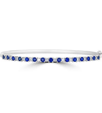 14K white gold bangle bracelet with alternating round sapphires and diamonds in prong setting