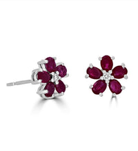 14K white gold floral stud earrings with oval rubies and round diamonds in a flower petal design
