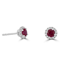 Close-up of 14K white gold round ruby and diamond halo stud earrings with secure post back.