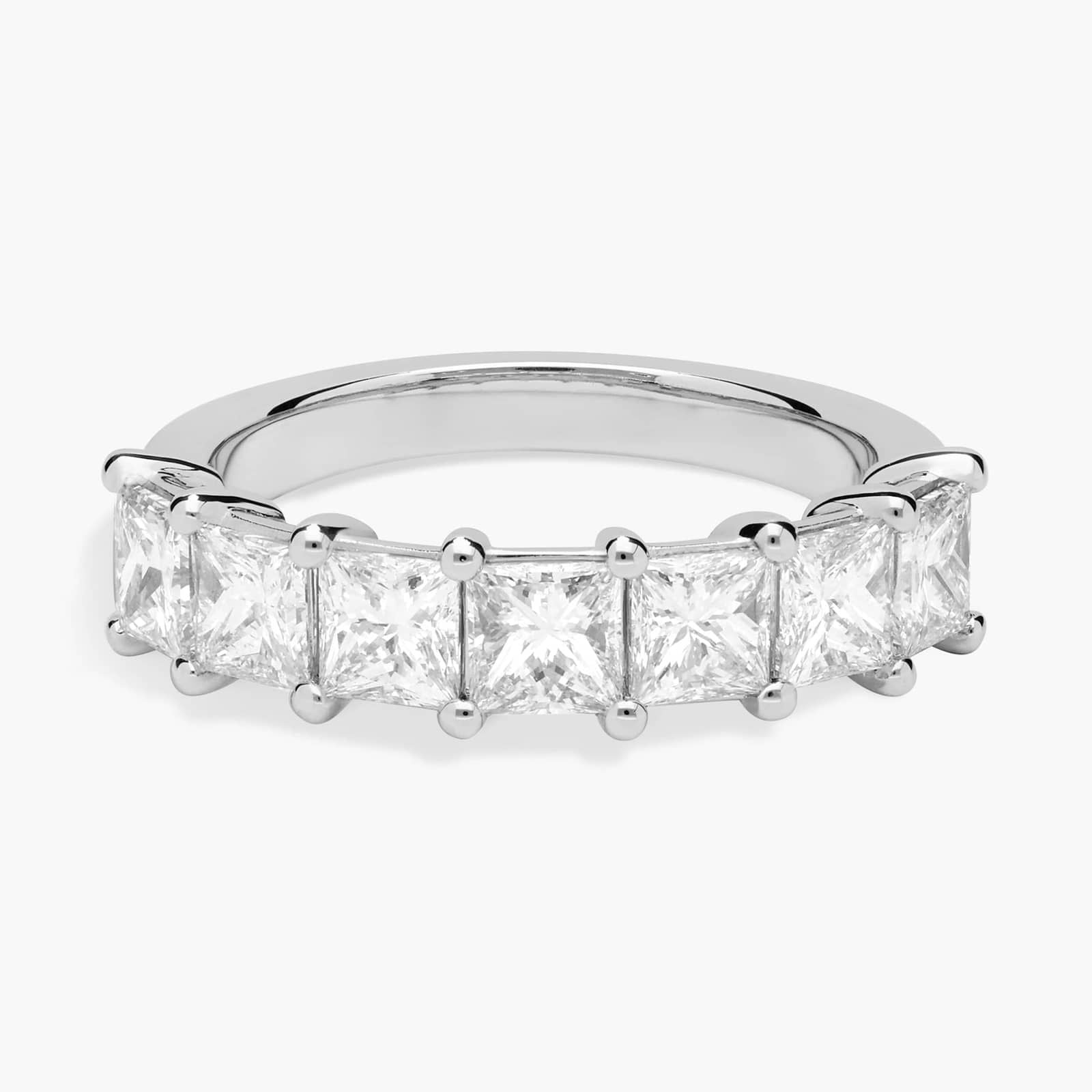 Princess cut lab-grown diamond eternity band in 14K white gold, displayed on model’s hand and white background.

