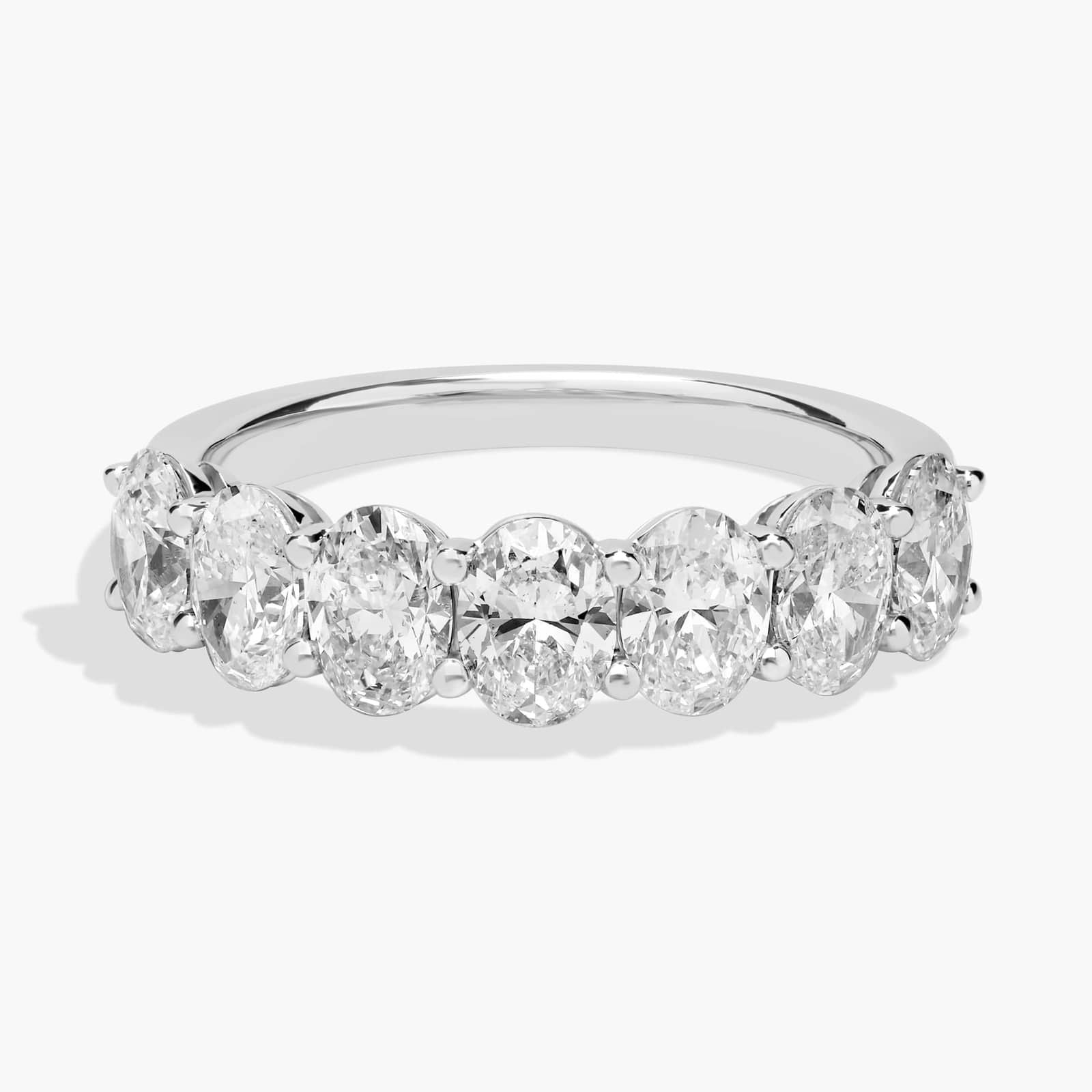 14K white gold oval-cut diamond eternity ring with lab-grown diamonds, handcrafted luxury band shown on model's hand.