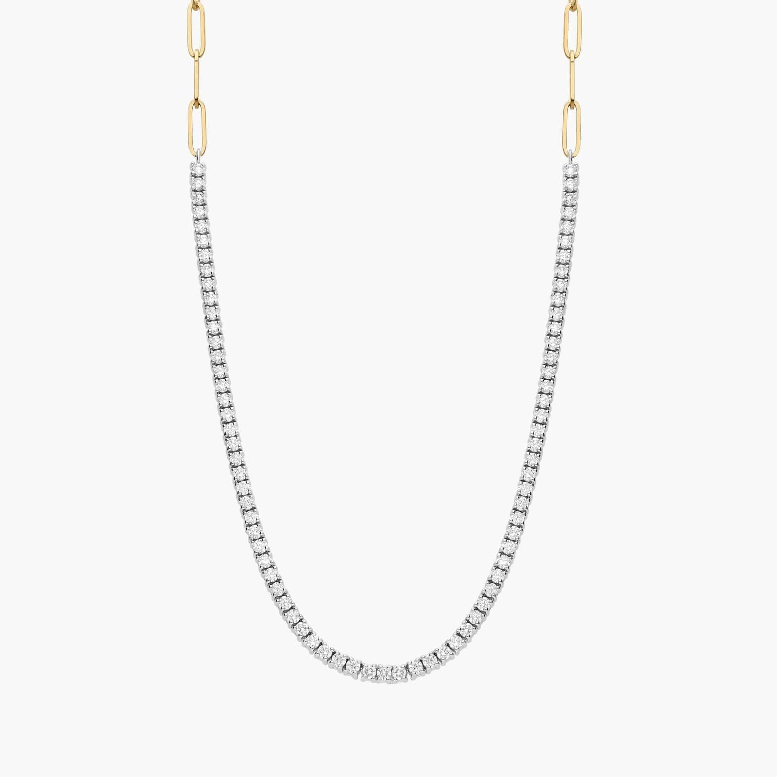 Two-toned 14K yellow gold paperclip and diamond tennis necklace worn by a woman.