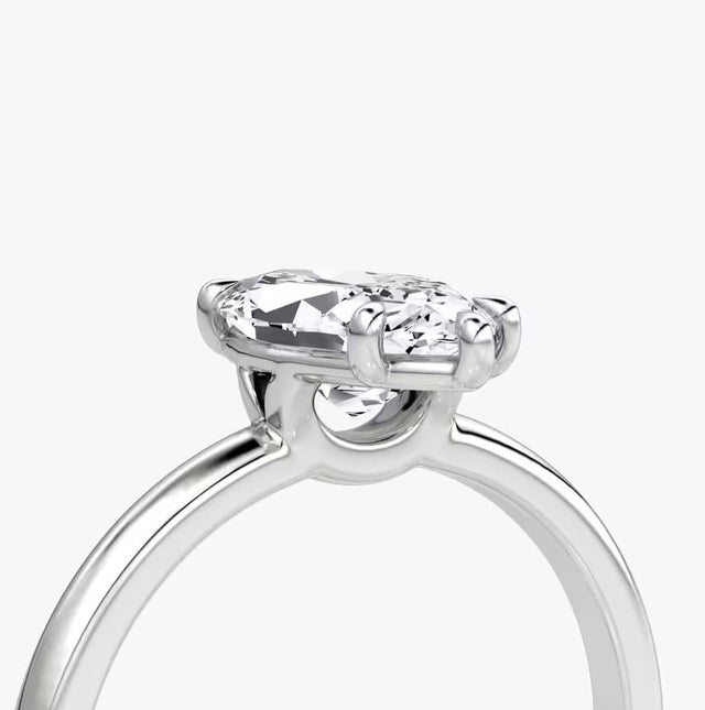 Elegant marquise diamond ring in 14K gold with pavé-set halo and cluster side accents, available in yellow, white, rose gold, or platinum.

