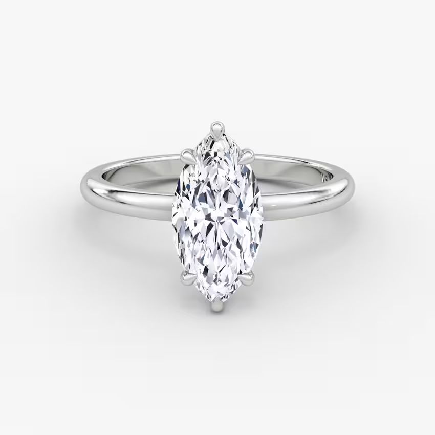 Elegant marquise diamond ring in 14K gold with pavé-set halo and cluster side accents, available in yellow, white, rose gold, or platinum.


