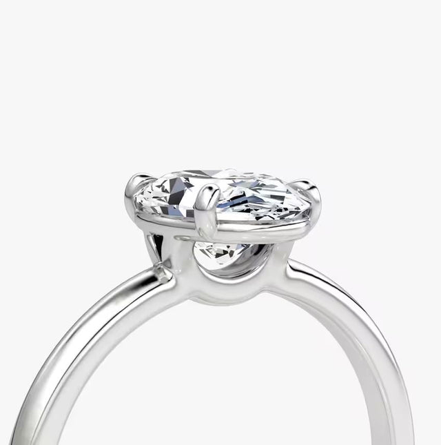 Side and front views of an oval-cut solitaire diamond engagement ring set in polished 14K white gold.