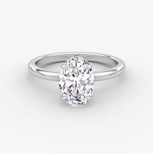 Side and front views of an oval-cut solitaire diamond engagement ring set in polished 14K white gold.